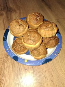 Aranybarnára sült, omlós diós kosárkák csillagmintás tányéron, háttérben világos fa felülettel.